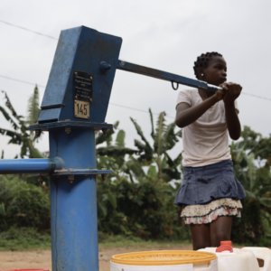 African girl operating a water pump
